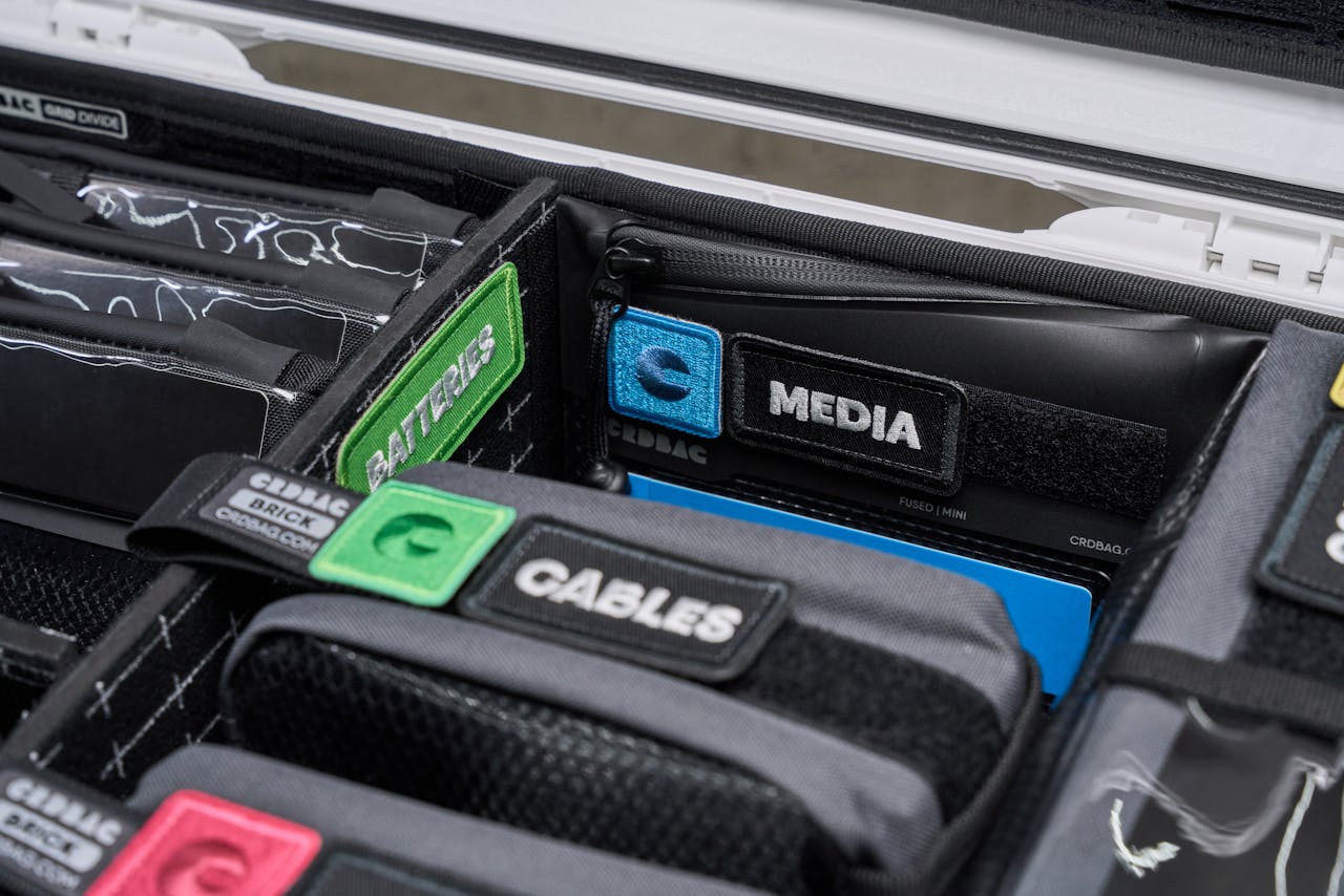 Close-up of organized camera gear in a hard case with labeled compartments for easy access.
